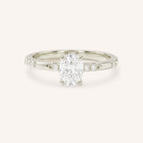 White Gold oval diamond engagement ring with accented band on white background