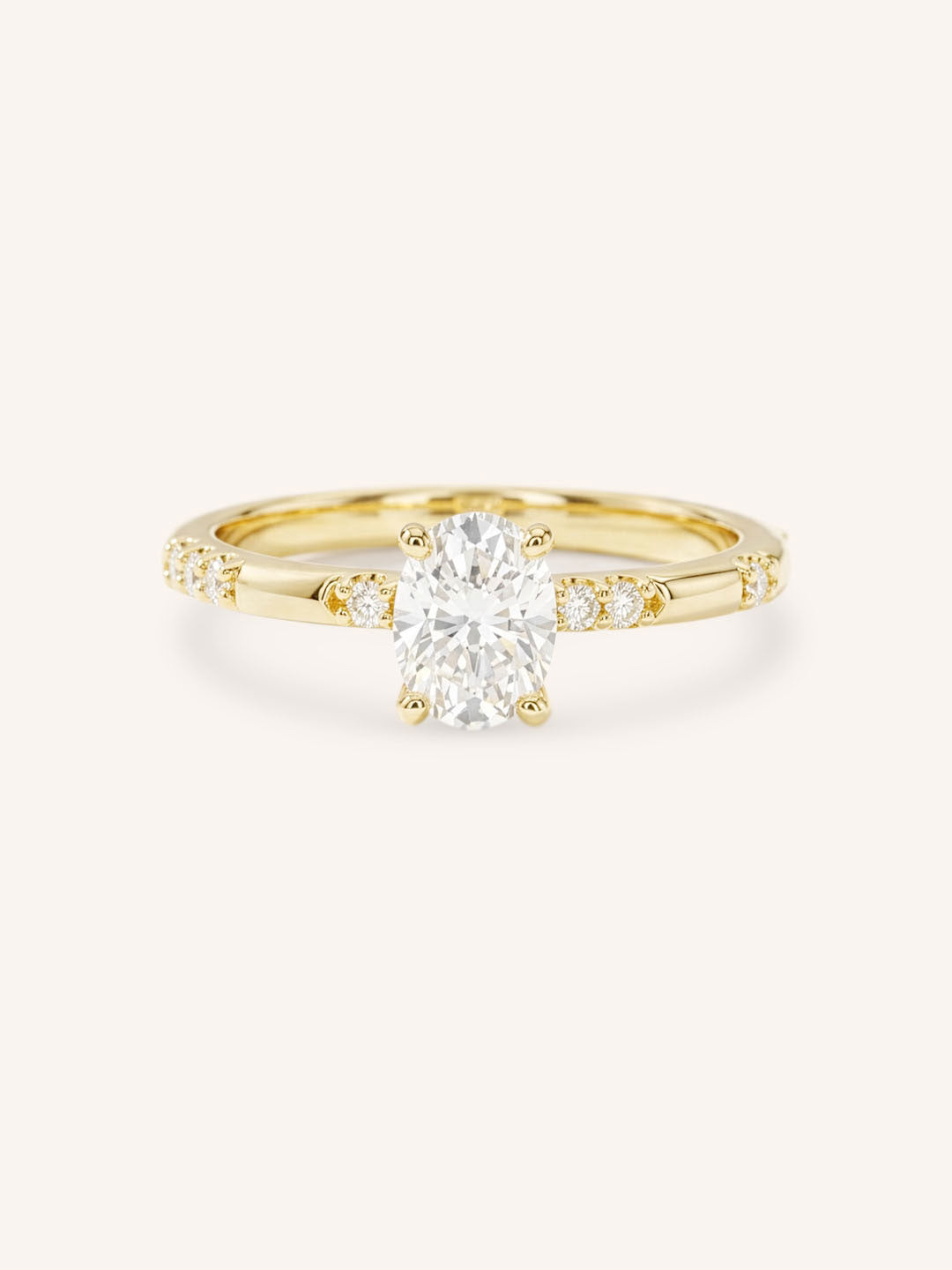 Yellow Gold oval diamond engagement ring with accented band on white background