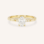 Yellow Gold oval diamond engagement ring with accented band on white background