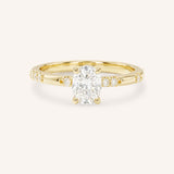 Yellow Gold oval diamond engagement ring with accented band on white background