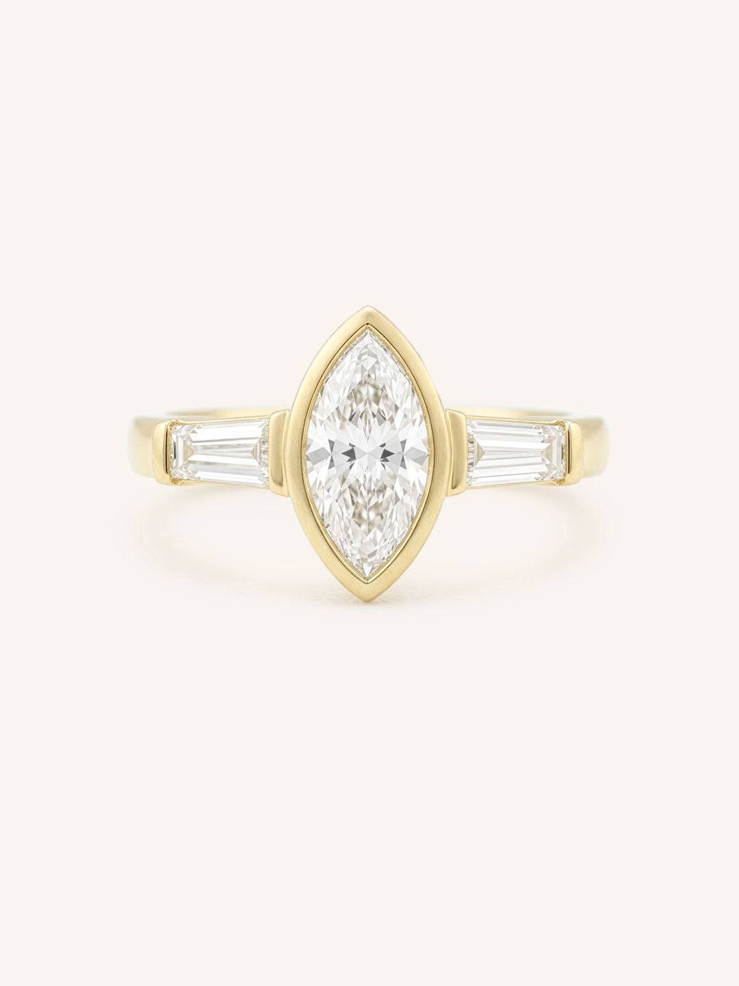 Yellow gold Grannis marquise three stone and baguette diamond engagement ring front view on white background