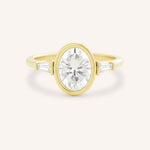 Yellow gold Grannis three stone oval and baguette diamond engagement ring front view on white background