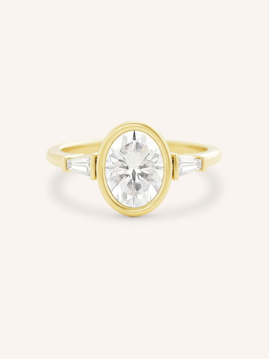 Yellow gold Grannis three stone oval and baguette diamond engagement ring front view on white background