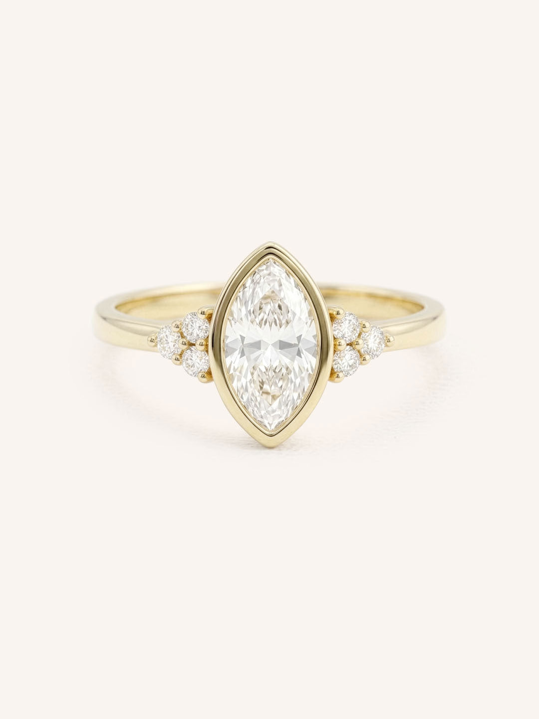 Yellow gold marquise cut bezel set diamond engagement ring with side stones on white background