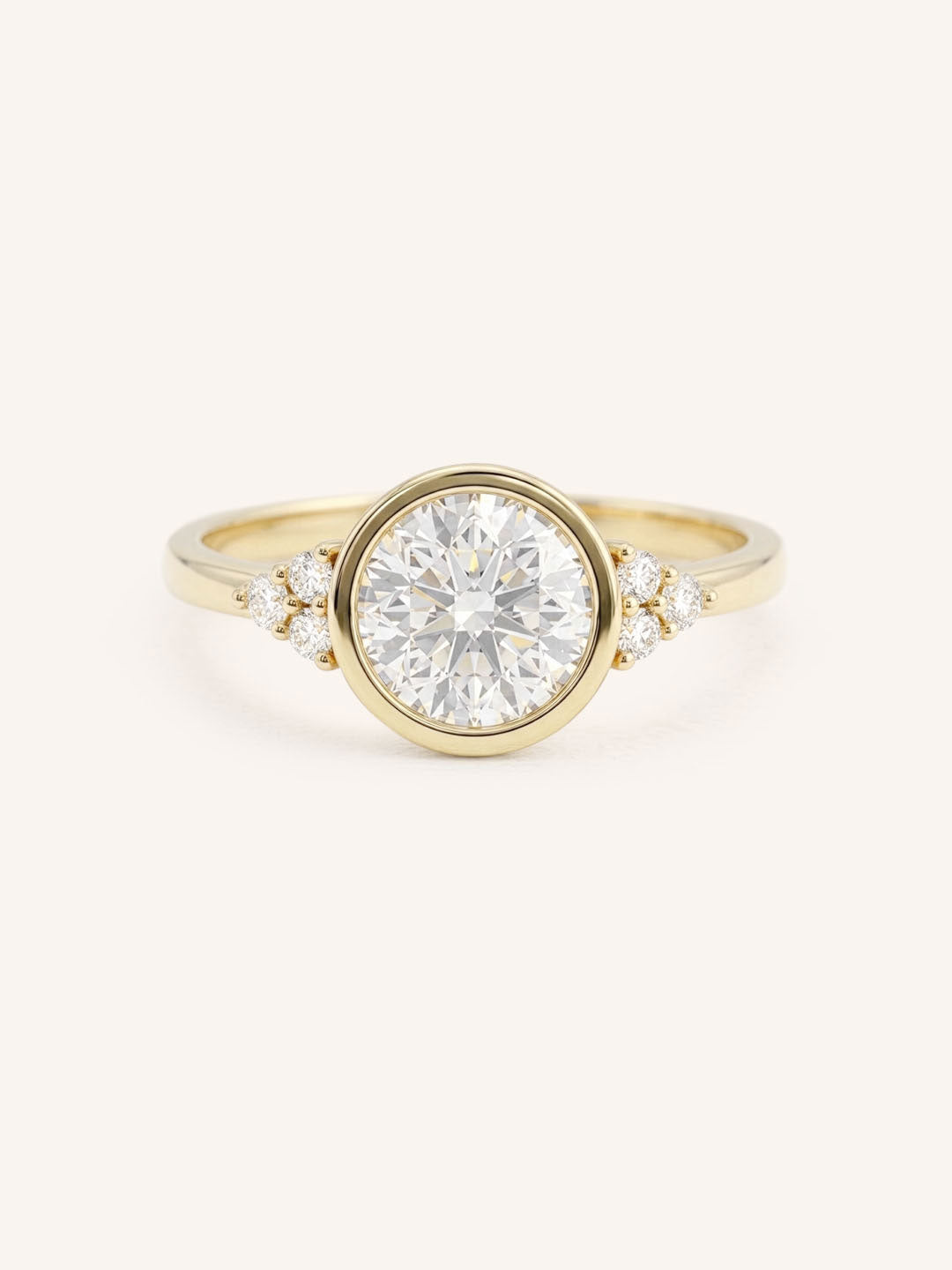 Yellow gold round cut bezel set diamond engagement ring with side stones on white background