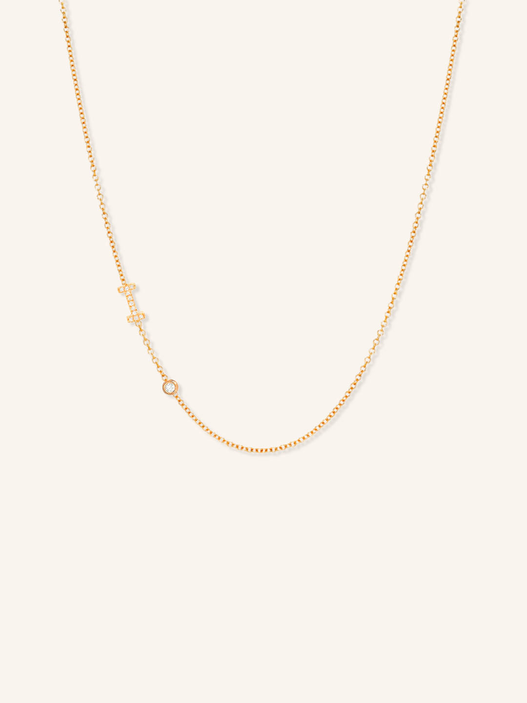 Rose gold asymmetrical diamond initial I and bezel necklace on white background