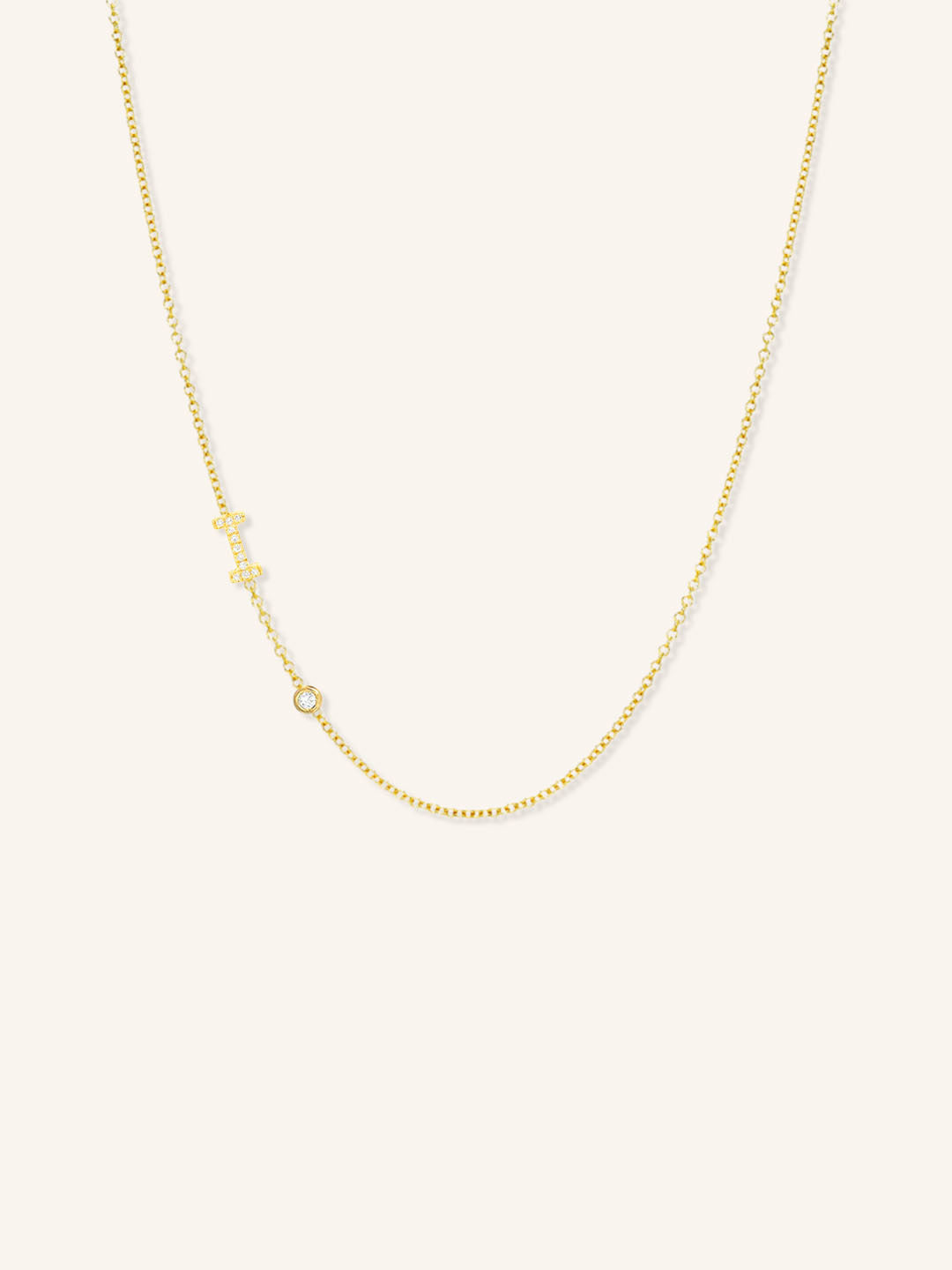 Yellow gold asymmetrical diamond initial I and bezel necklace on white background