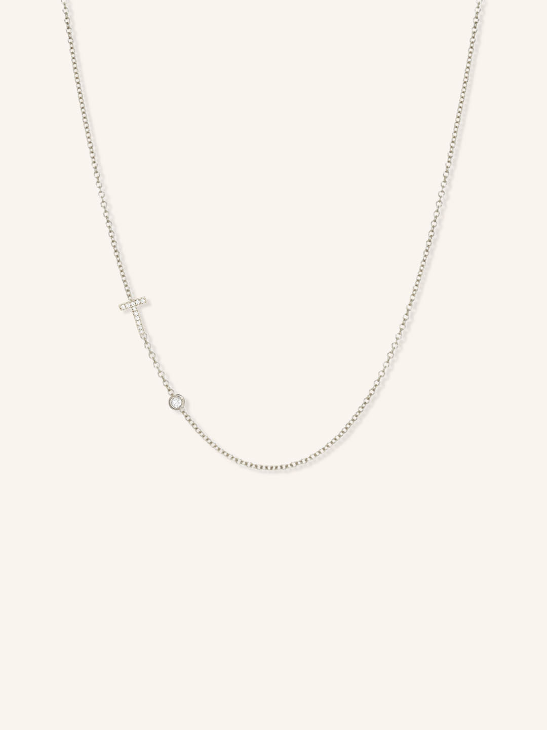White gold asymmetrical diamond initial T and bezel necklace on white background