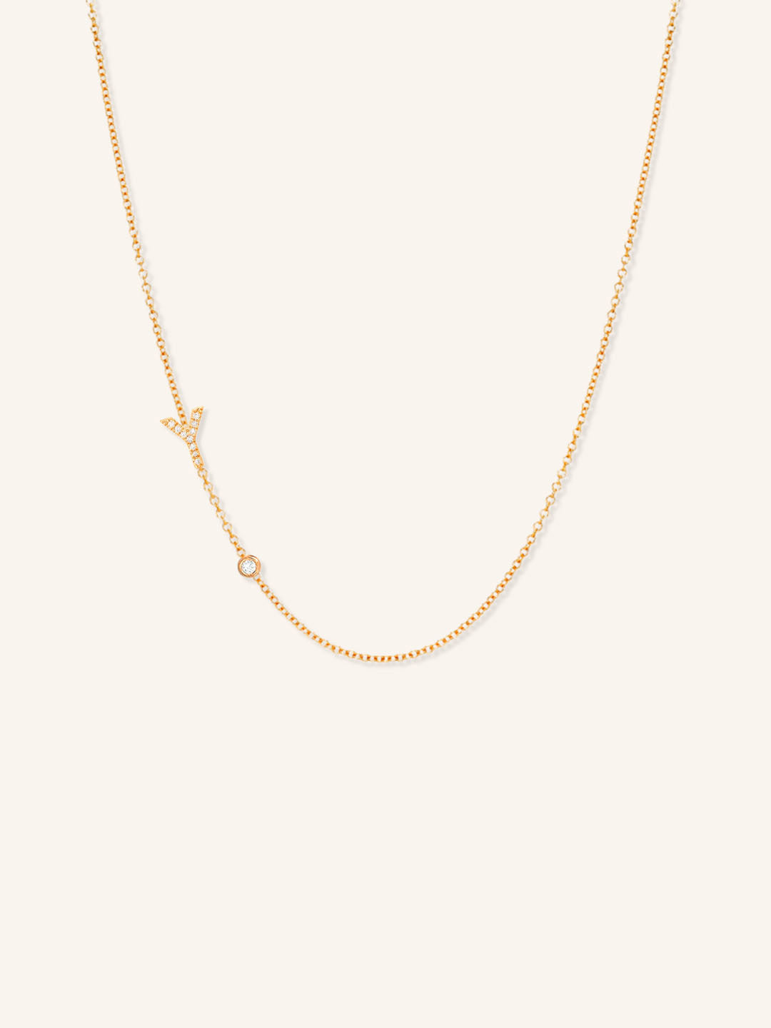 Rose gold asymmetrical diamond initial Y and bezel necklace on white background