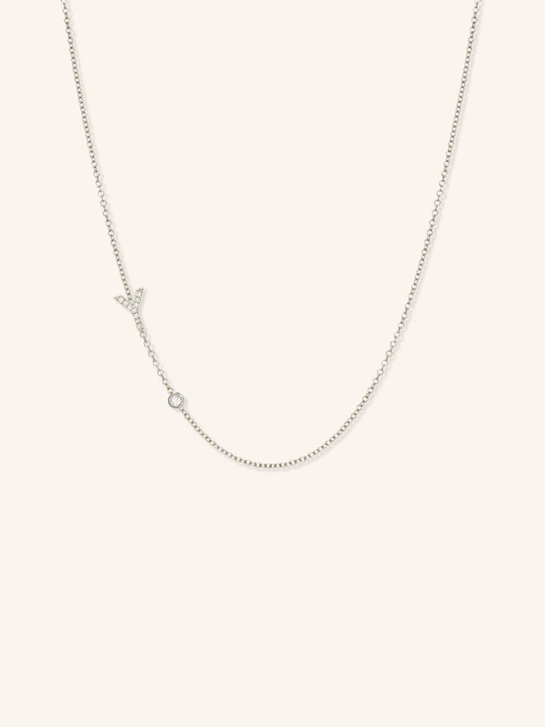 White gold asymmetrical diamond initial Y and bezel necklace on white background