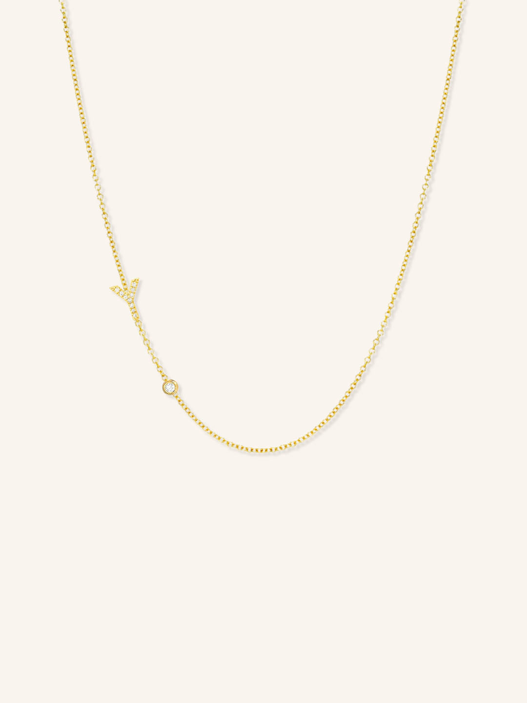 Yellow gold asymmetrical diamond initial Y and bezel necklace on white background