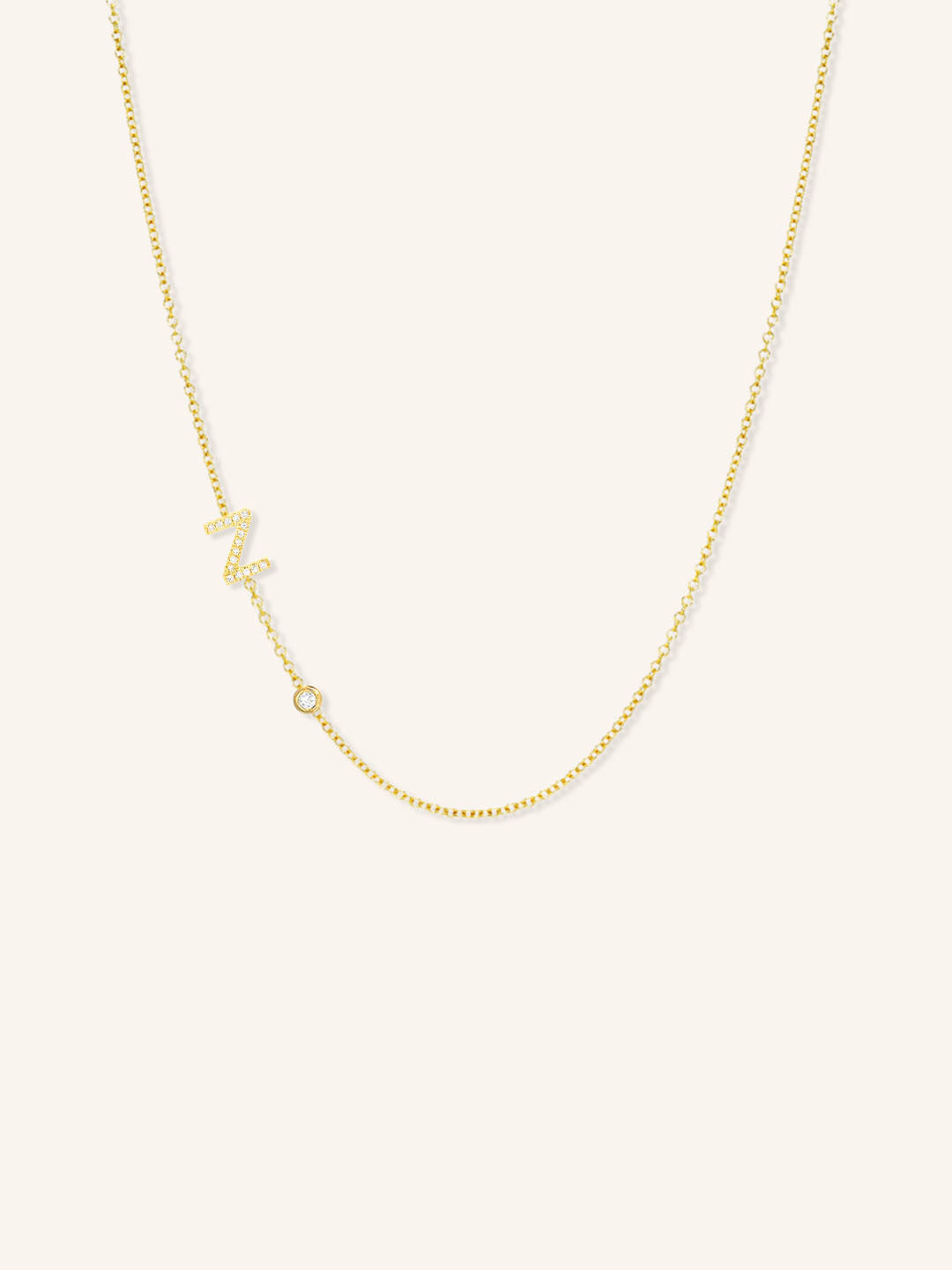 Yellow gold asymmetrical diamond initial Z and bezel necklace on white background
