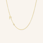 Gold necklace with a small pendant on a light beige background