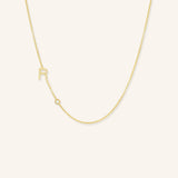 Gold necklace with a small pendant on a light beige background