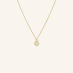 A gold-colored necklace with a small heart-shaped pendant featuring diamond accents.
