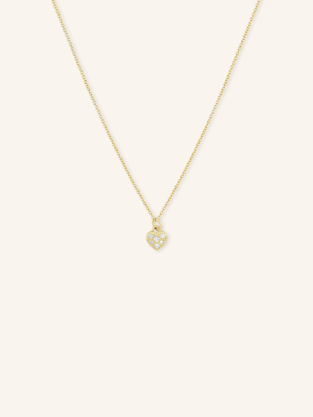 A gold-colored necklace with a small heart-shaped pendant featuring diamond accents.
