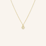 A gold-colored necklace with a small heart-shaped pendant featuring diamond accents.