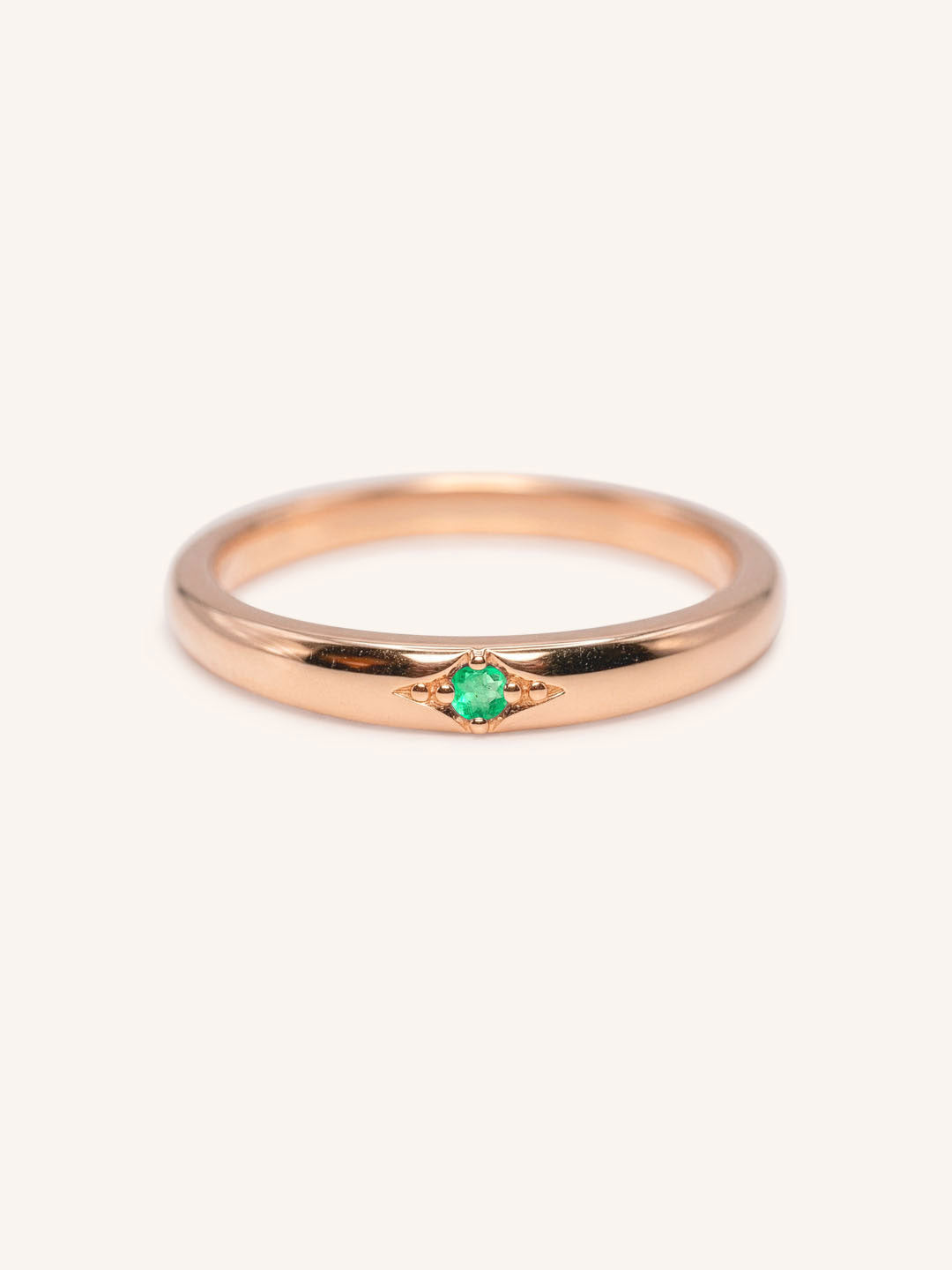 Rose gold Beacon emerald stackable ring front view on white background