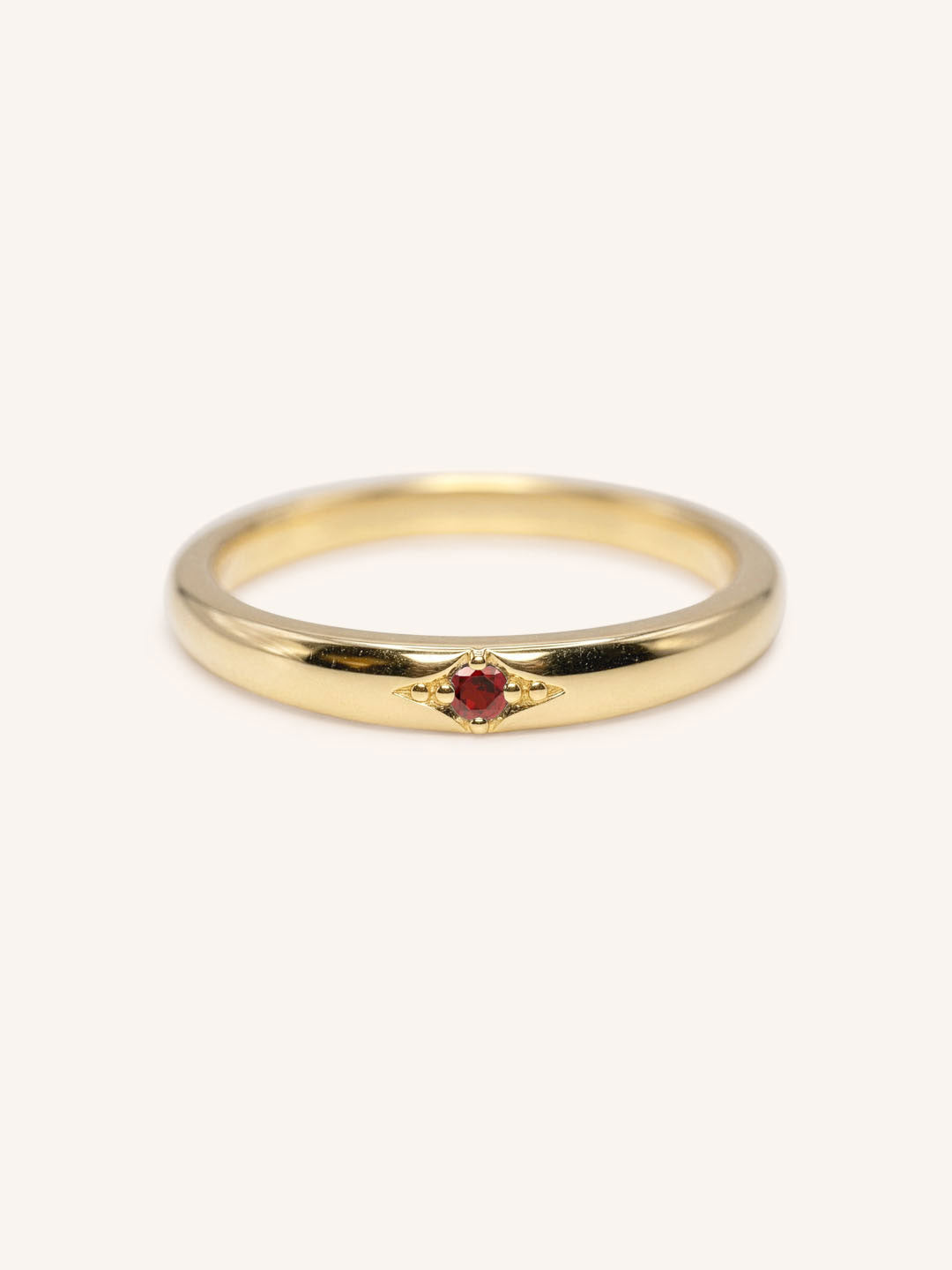 Yellow gold Beacon garnet stackable ring front view on white background