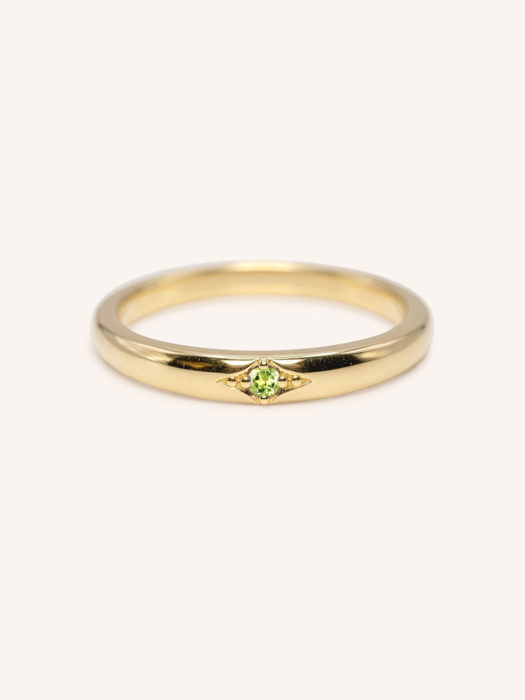 Yellow gold Beacon peridot stackable ring front view on white background