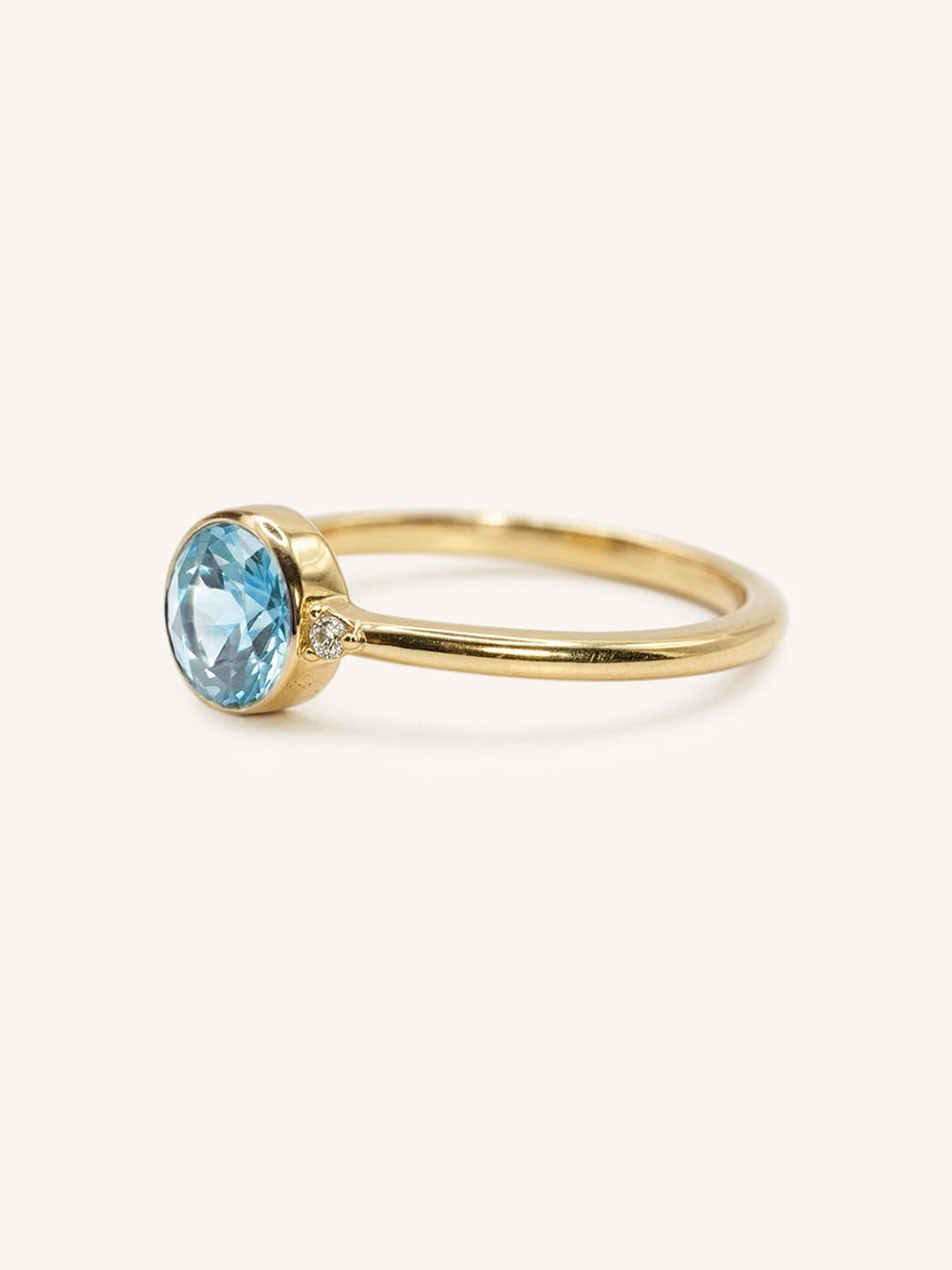 Yellow gold aquamarine and diamond ring side view on white background