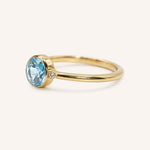 Yellow gold aquamarine and diamond ring side view on white background