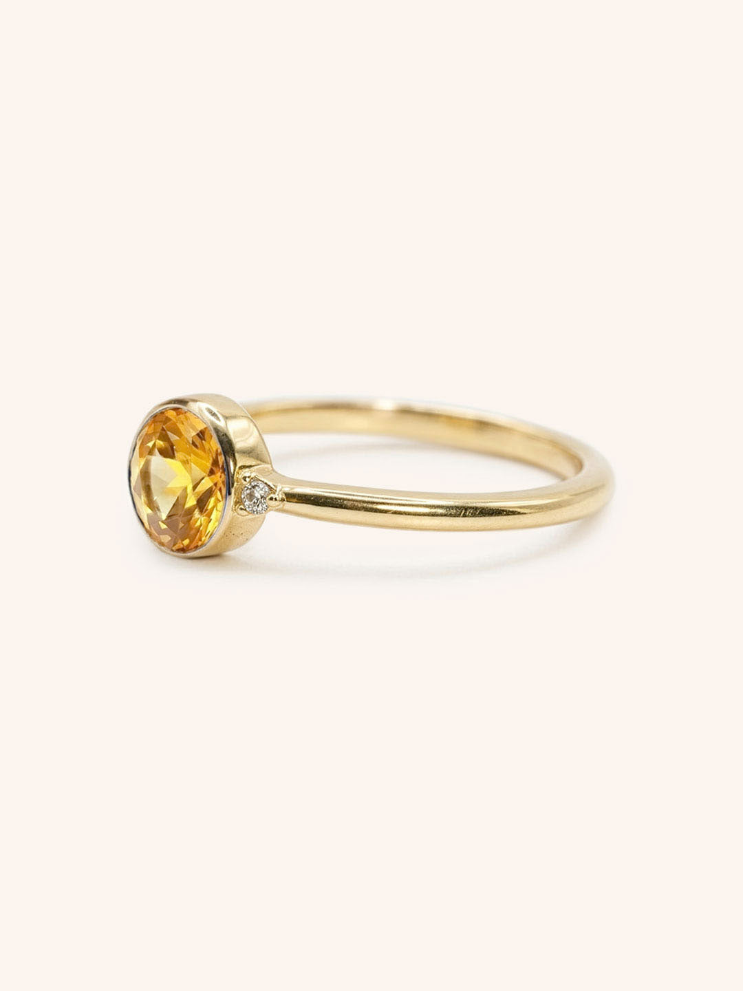 Yellow gold citrine and diamond ring side view on white background