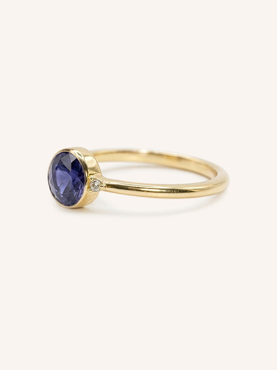 Yellow gold iolite and diamond ring side view on white background
