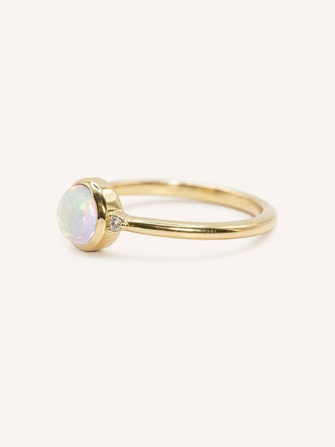 Yellow gold opal and diamond ring side view on white background