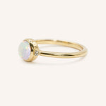 Yellow gold opal and diamond ring side view on white background