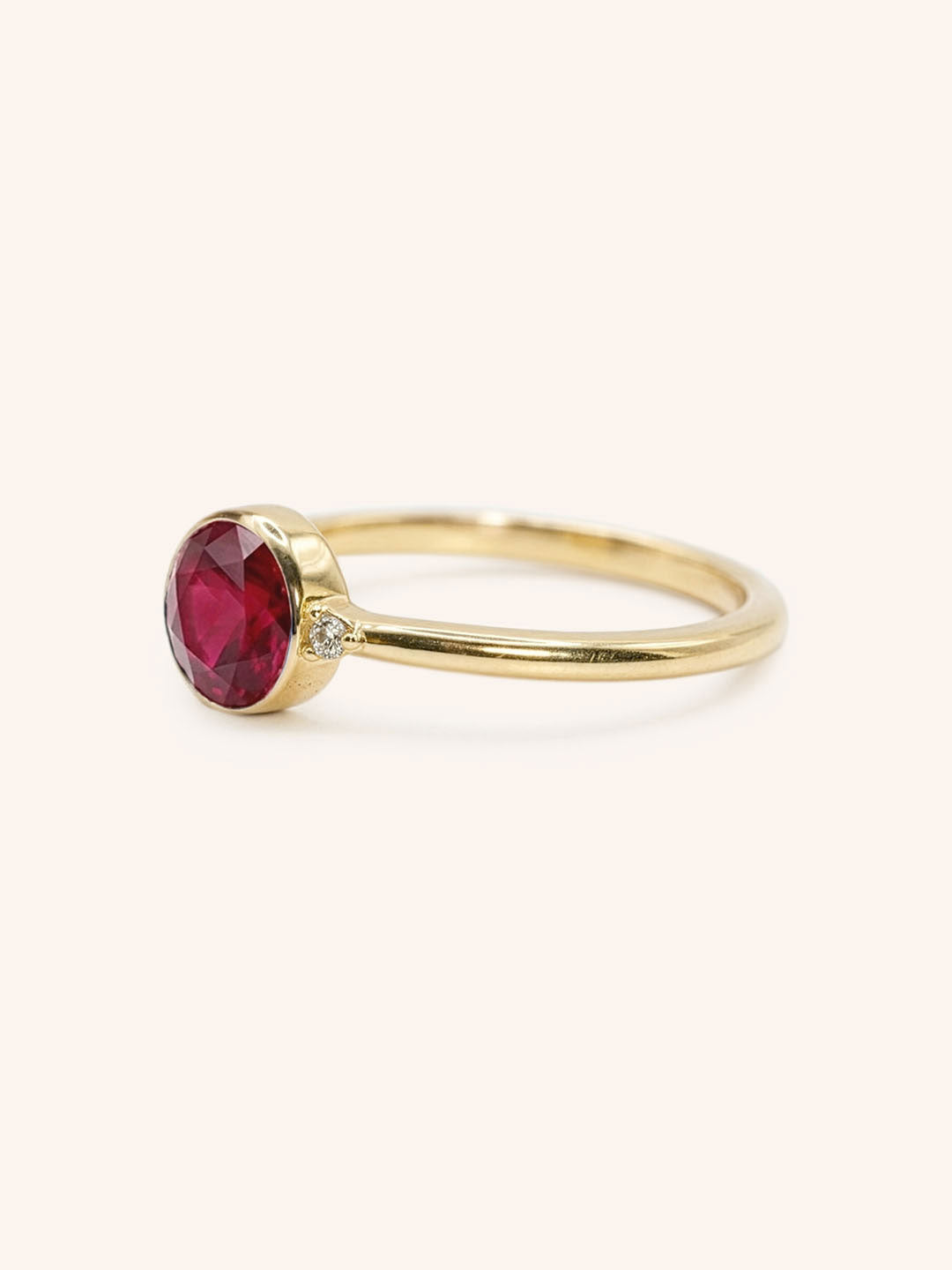 Yellow gold ruby and diamond ring side view on white background