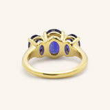 Yellow gold Trielle three stone oval cut blue sapphire ring back view on white background