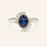 White gold Marlowe oval blue sapphire cluster diamond ring front view on white background