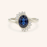 White gold Marlowe oval blue sapphire cluster diamond ring front view on white background