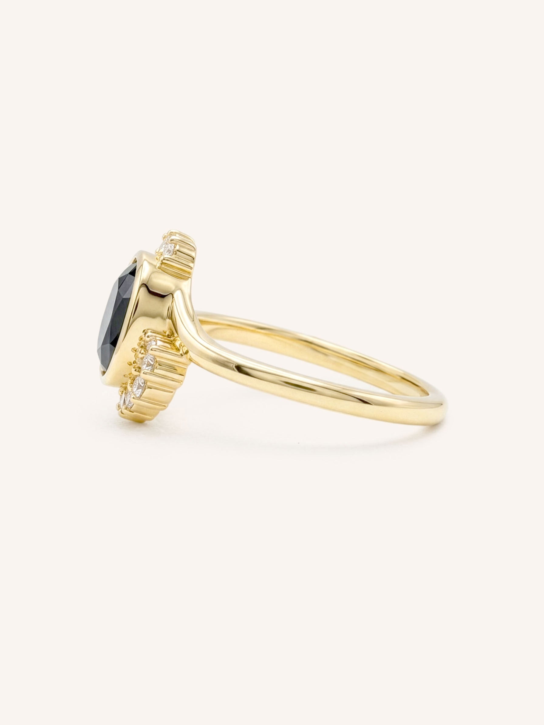 Yellow gold Marlowe oval blue sapphire cluster diamond ring side view on white background