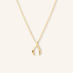 A gold-colored necklace in the shape of a wishbone.