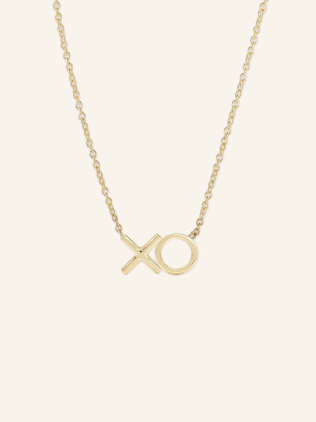 A gold-colored necklace with an X-shaped pendant on a chain.