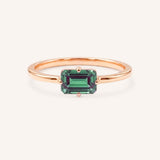 Rose gold solitaire ring with emerald-cut alexandrite gemstone on white background