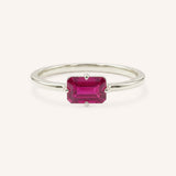 White gold solitaire ring with emerald-cut ruby gemstone on white background