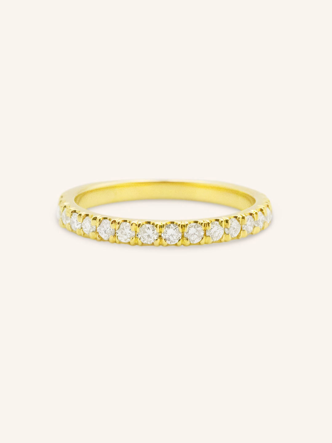 A gold half eternity band featuring a row of embedded white diamonds.