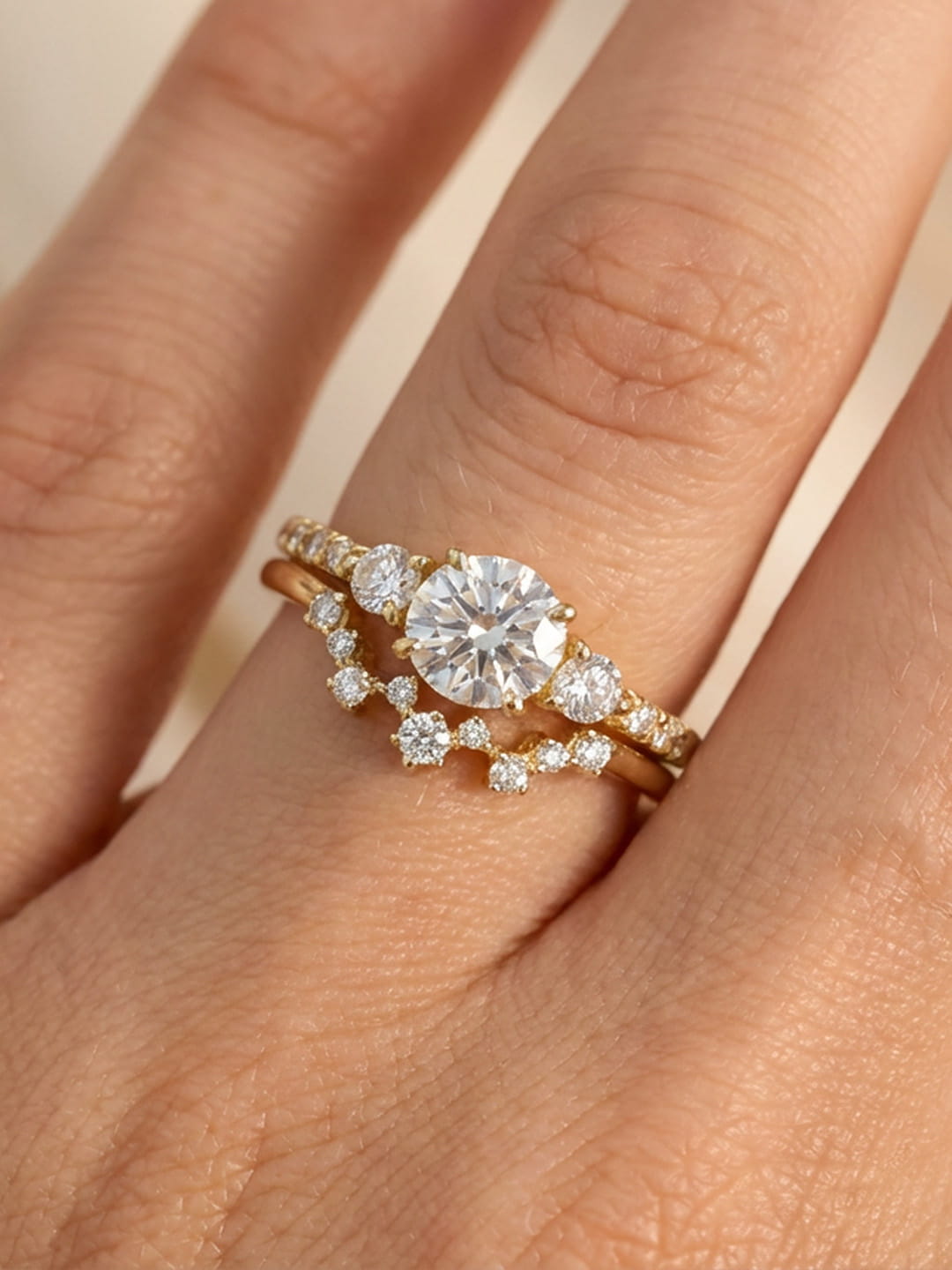 Close-up of hand wearing yellow gold Twinkle diamond ring stacked with wedding band
