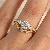 Close-up of hand wearing yellow gold Twinkle diamond ring stacked with wedding band