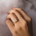 Gold princess cut diamond engagement ring with diamond wedding band worn on hand