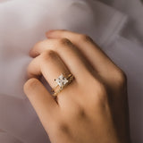 Gold princess cut diamond engagement ring with diamond wedding band worn on hand