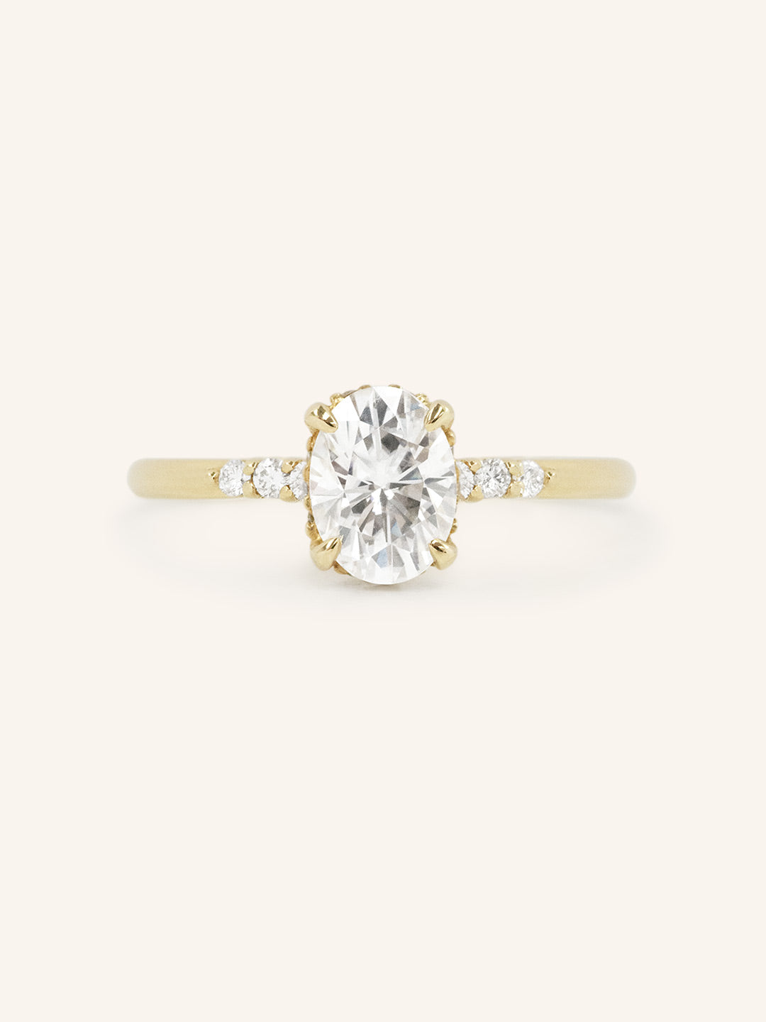 Yellow Gold Hidden Halo Oval Moissanite Engagement Ring with Diamond Accents front view on white background