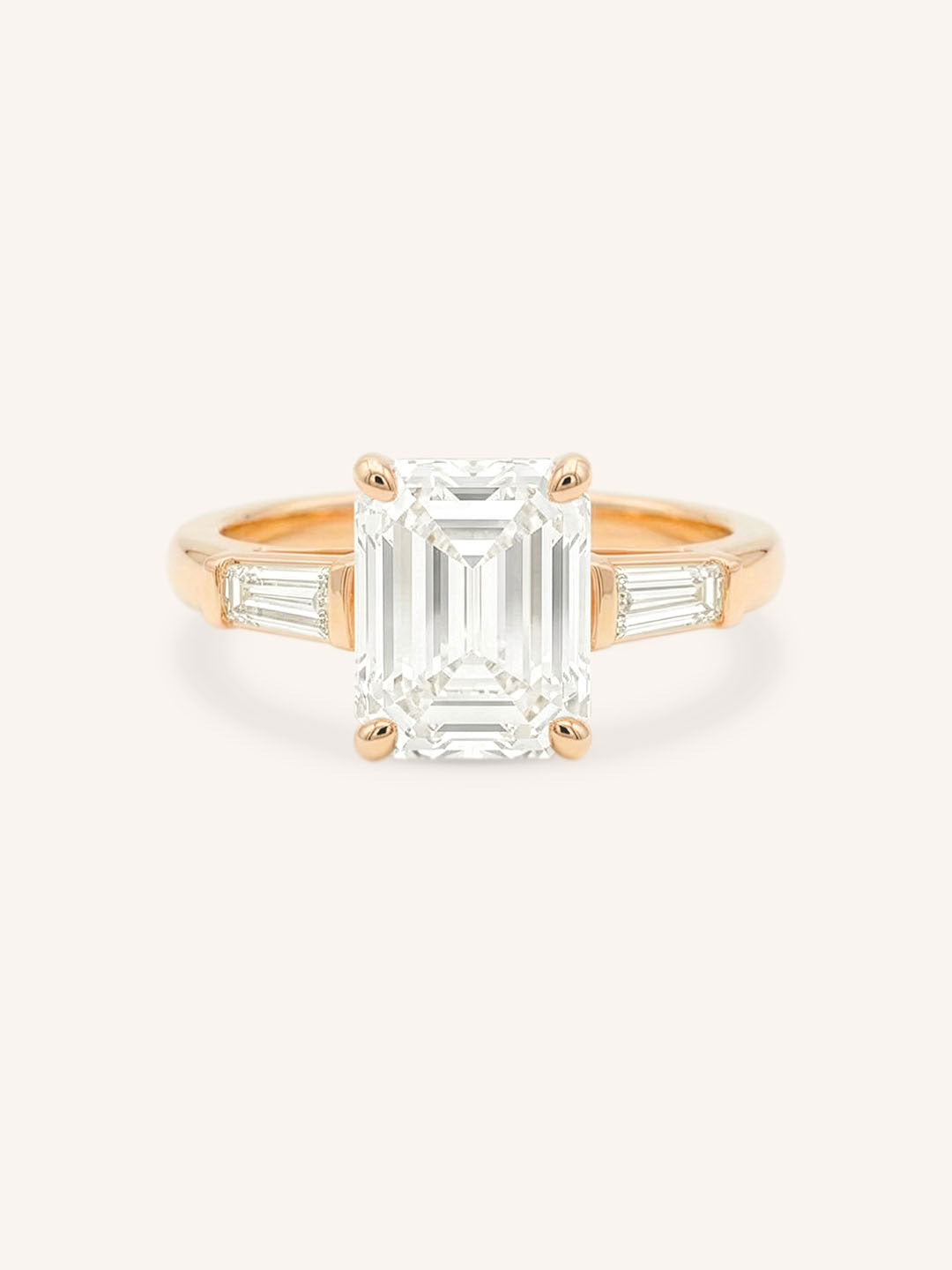 Rose gold Stately Manor emerald cut diamond three stone engagement ring with baguette accents front view