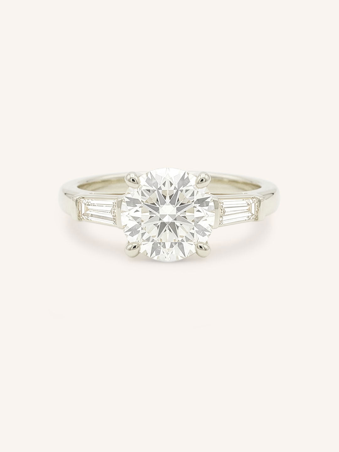 White gold Stately Manor round diamond three stone engagement ring with baguette accents front view