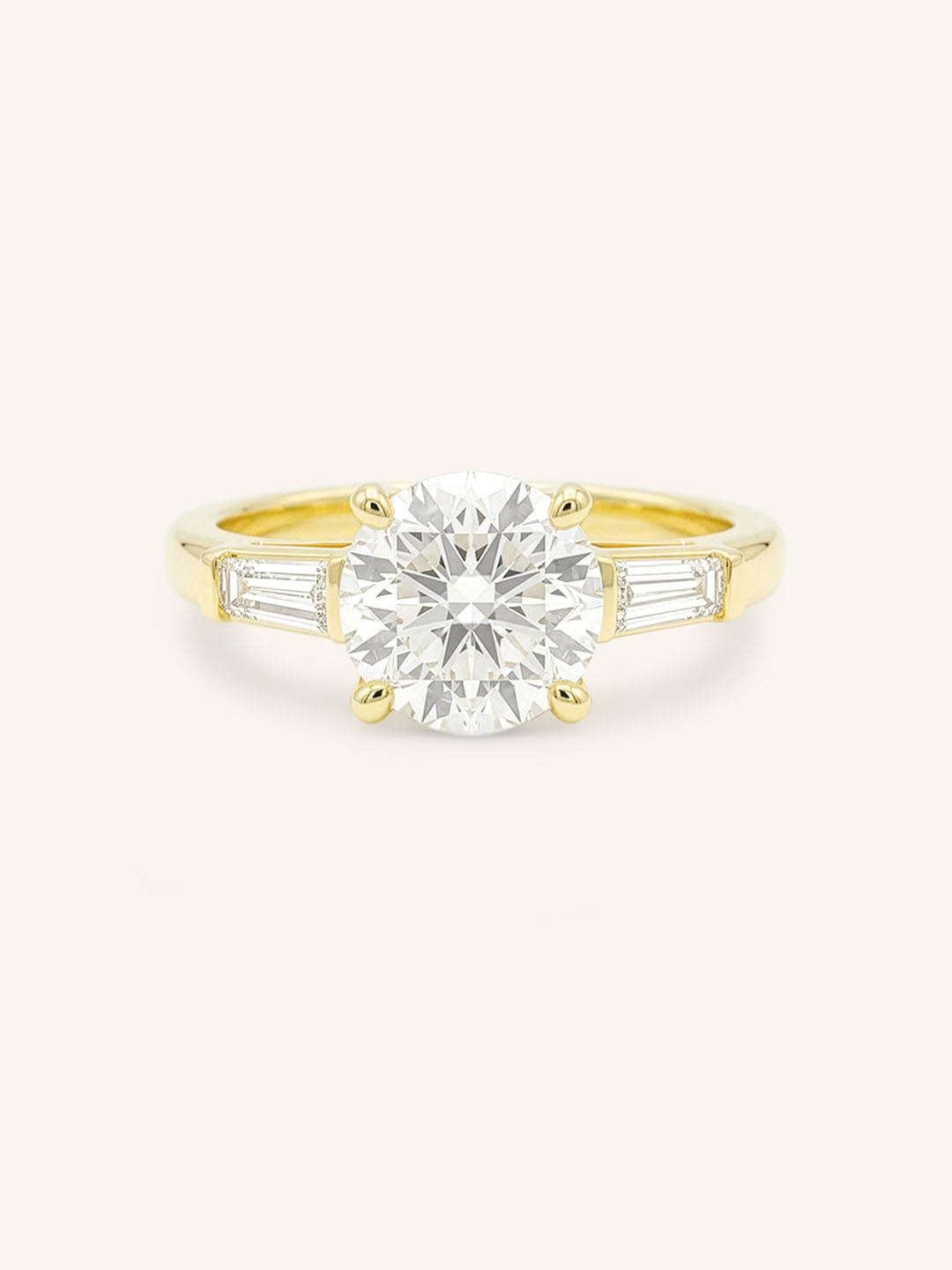 Yellow gold Stately Manor round diamond three stone engagement ring with baguette accents front view