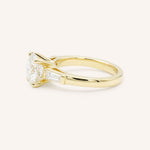 Yellow gold Stately Manor round diamond three stone engagement ring with baguette accents side view