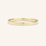 A flat, 2MM wide, gold wedding band on a plain background.
